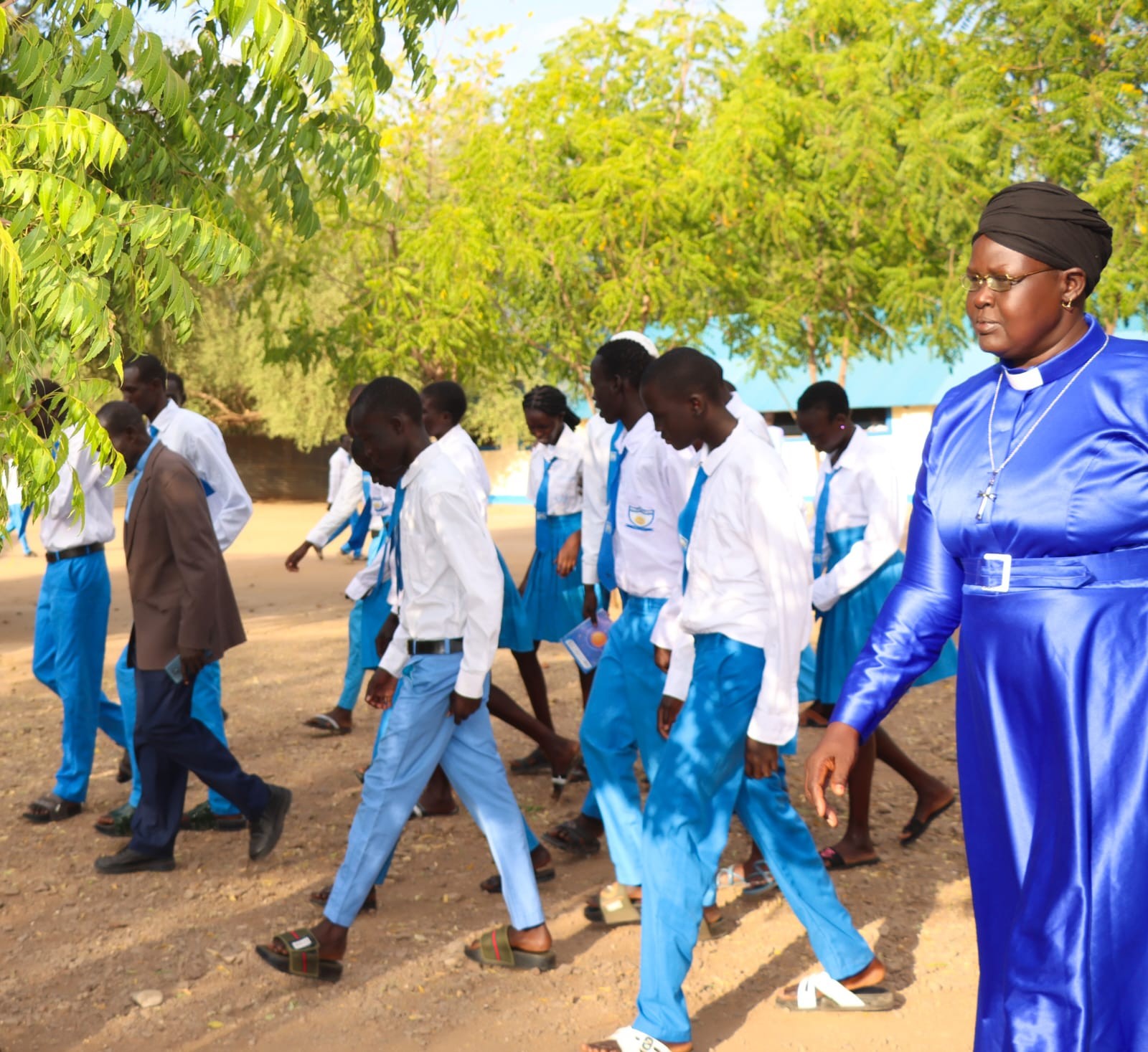 Students and school leaders walking through the school compound.